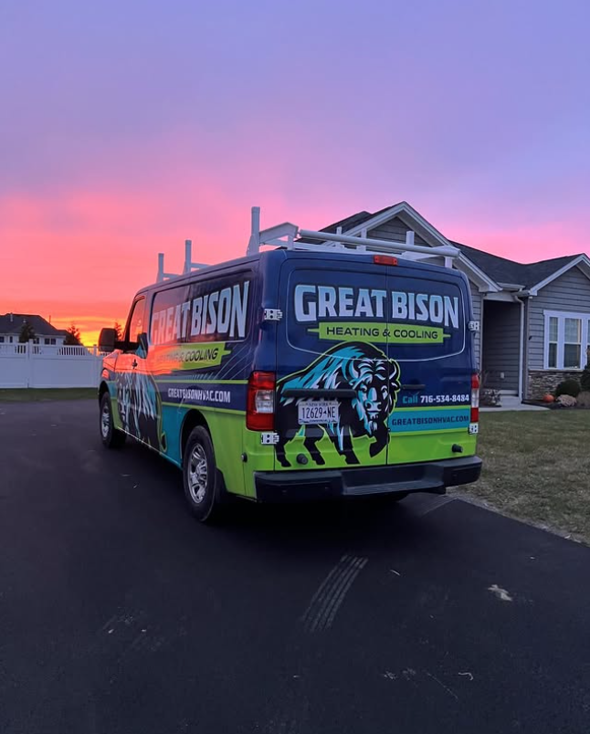 A Great Bison Heating & Cooling service van is parked in a driveway near a house at sunset.